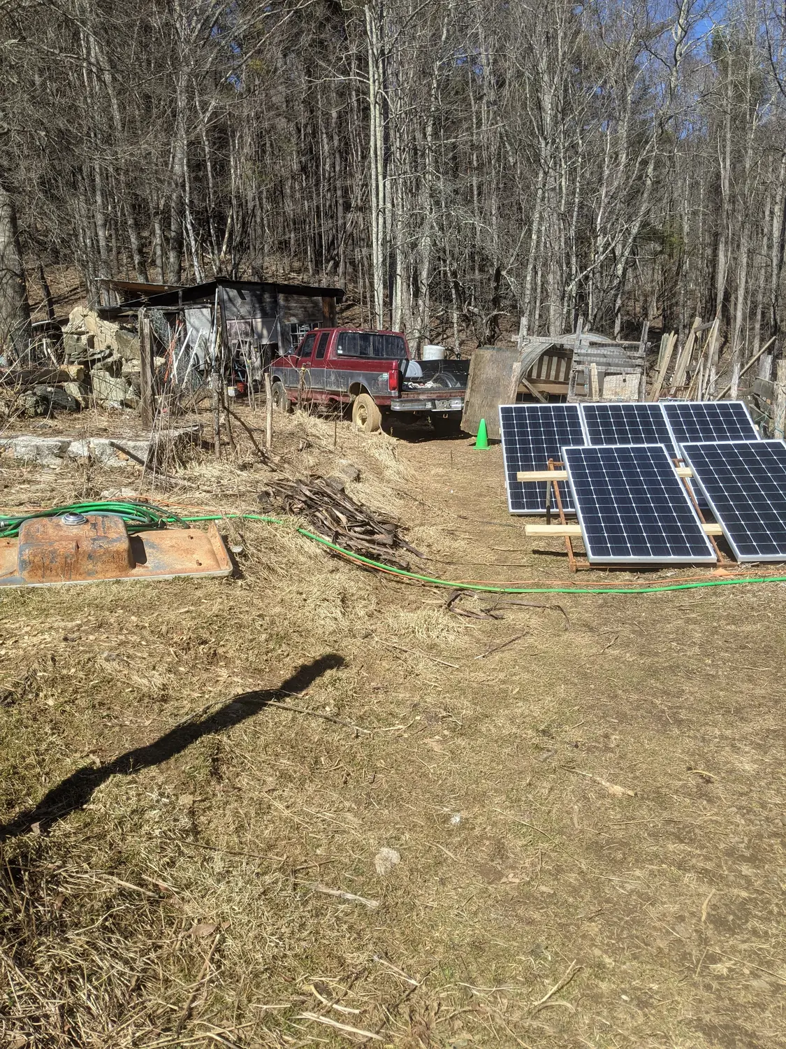 An array of solar panels, with a rusty truck in the background